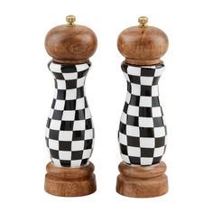 two black and white checkered salt and pepper shakers on wooden bases with gold caps