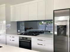 a modern kitchen with stainless steel appliances and white cabinets