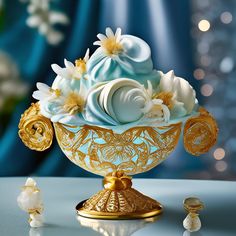 a fancy blue and white cupcake on a gold stand with other decorations around it