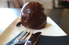 a piece of chocolate on a plate with silverware