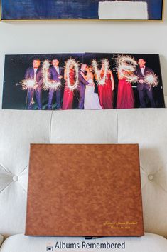 two framed pictures hang on the wall above a couch with a couple's wedding photos