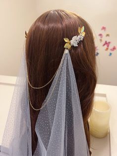 the back of a woman's head wearing a veil with flowers on it