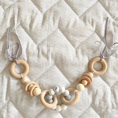 a necklace made out of wooden beads on top of a white quilted bed sheet