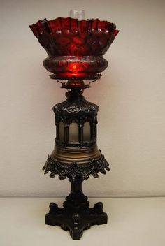 a red lit candle is sitting on a stand