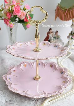 two tiered trays with pink and gold designs on them, each holding a cake stand