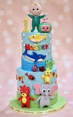 a three tiered cake decorated with animals and letters