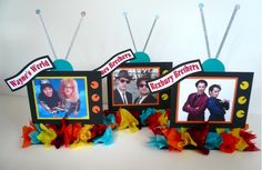 three small televisions with pictures on them sitting next to some streamers and ribbons