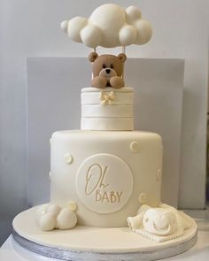 a baby shower cake with a teddy bear on top