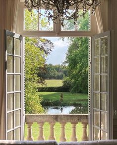 an open window with a view of a pond