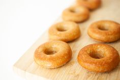 several donuts are lined up on a cutting board and ready to be eaten by someone