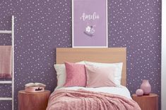 a bedroom with purple wallpaper and pink bedding