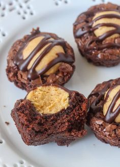 chocolate cookies with peanut butter in the middle on a white plate