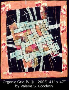 an orange and black quilt with pink flowers on the border, in front of a black background