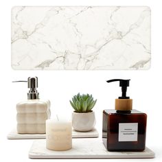 bathroom accessories including soap dispenser, candle and succulent on white background