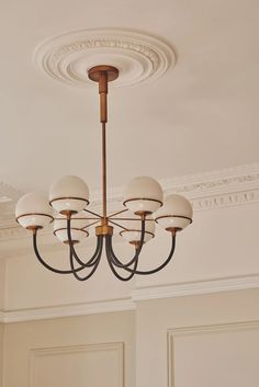 a chandelier hanging from the ceiling in a room with white walls and doors