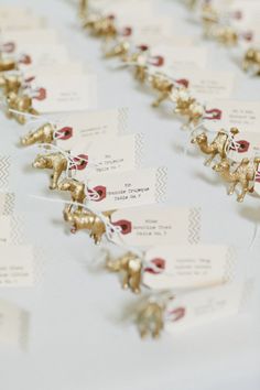 many small gold elephants are attached to white tags