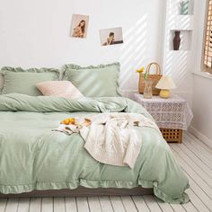 a bed with green sheets and pillows in a room