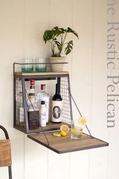 a shelf with bottles and glasses on it next to a chair in front of a wall