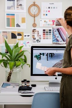 a woman standing in front of a computer screen