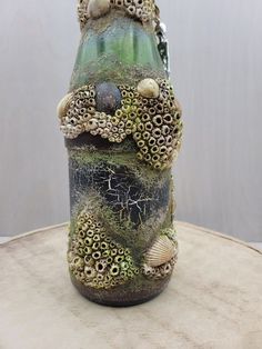 there is a vase with sea shells on it