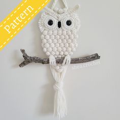 an owl ornament hanging on a tree branch