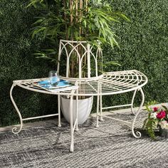 a white table sitting on top of a rug next to a potted bamboo plant