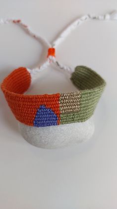 a close up of a knitted headband on a white surface with strings attached