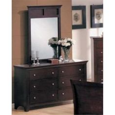 a bedroom with a dresser, mirror and flowers in vases on the top shelf