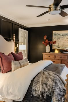 a bedroom with black walls and white bedding