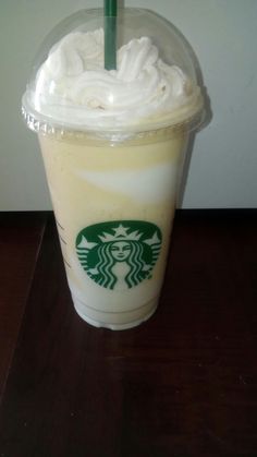 a starbucks drink with whipped cream and a green straw