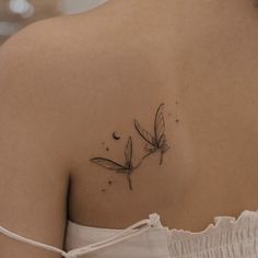 the back of a woman's shoulder with a flower tattoo on it