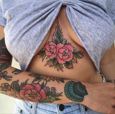 a woman's stomach with tattoos and flowers on it