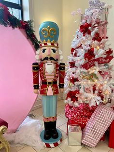 a nutcracker standing next to a christmas tree