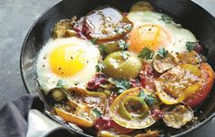 an iron skillet filled with eggs and vegetables