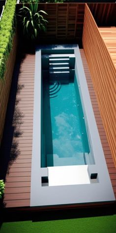 an above ground swimming pool in the middle of a backyard with wooden decking and green plants