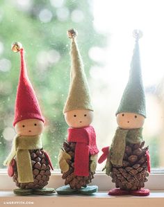 three little gnomes sitting next to each other on top of a window sill