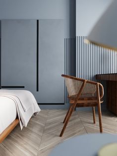 a bed sitting next to a wooden chair on top of a hard wood floor