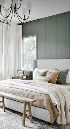 a bedroom with a large bed and a chandelier hanging from it's ceiling