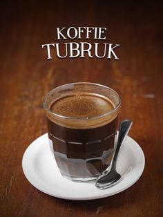 a cup of coffee on a saucer with a spoon next to it and the words koffie tubruk above it