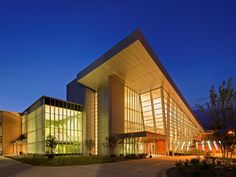 a large building lit up at night with lights shining on the outside and inside it