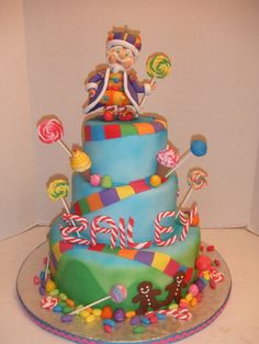 there is a multi layer cake decorated with candy and lollipops on top