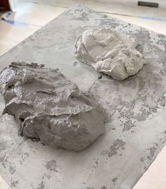 two pieces of clay sitting on top of a table