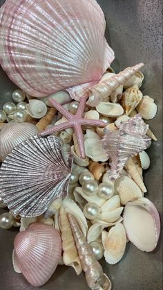 seashells and pearls in a bowl on the beach