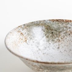 a white bowl with brown speckles on it