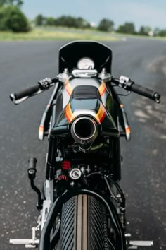 the front end of a motorcycle parked on the side of the road with trees in the background