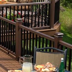 an outdoor table with food on it and chairs around it, overlooking the backyard area