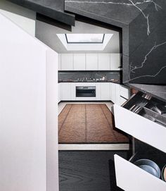 a kitchen with white cabinets and black marble counter tops is seen through an opening in the wall