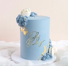 a blue and gold cake with flowers on top