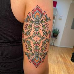 a woman's arm with a colorful tattoo design on the left side of her body