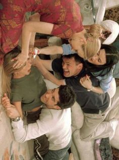 a group of people standing around each other in the middle of a circle with their hands together